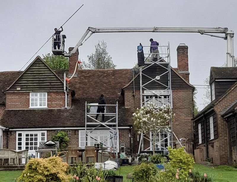The Moss Cleaners using cherry picker and scaffolding to clean roof safely and professionally in Chessington, {{COUNTY}}